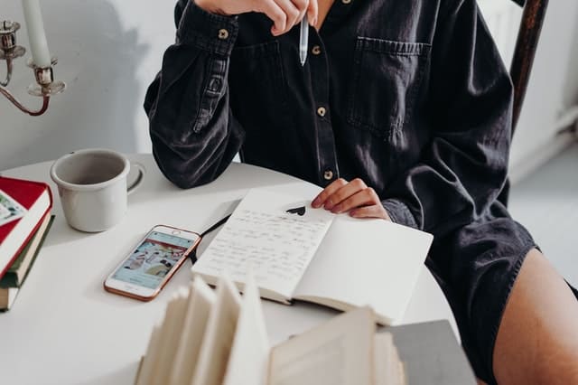 person-journaling-on-wooden-chair